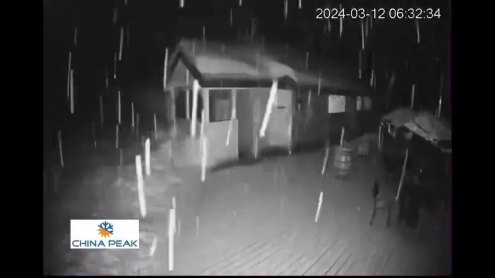 The footage was captured by a mountain camera set up by China Peak Mountain Resort in Lakeshore, California, and shows the snow coating one of their buildings Tuesday morning.