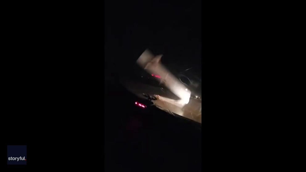 This video was part of a live feed on Facebook on Saturday. Initially, the storm chasers can't see the massive tornado crossing the road in front of them. Then the power flashes illuminate the twister. About halfway through the video, a huge chunk of truck falls from the sky and the family narrowly miss it.