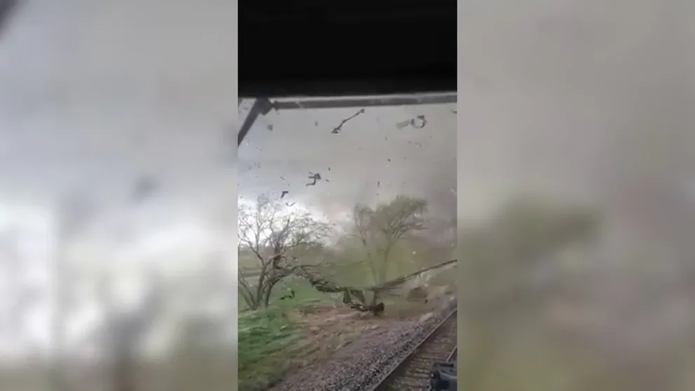 A train conductor waiting for a signal change saw a massive EF-3 tornado coming toward him on April 26 in Waverly, Nebraska. He held on as the twister knocked over train cars and broke windows. 