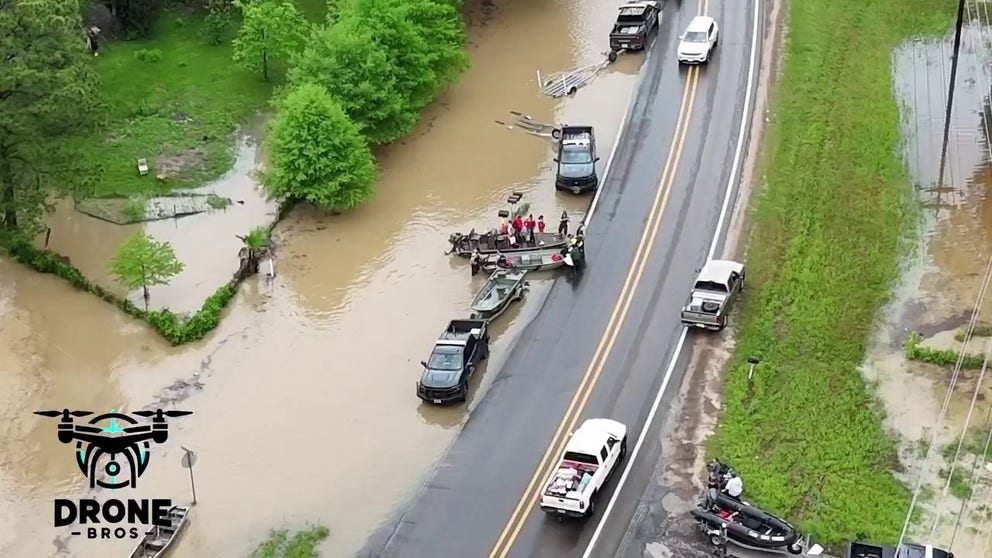 Drone footage over Livingston, Texas shows emergency crews with boats, suiting up for swift water rescues of residents trapped in their homes and cars, despite an evacuation order.