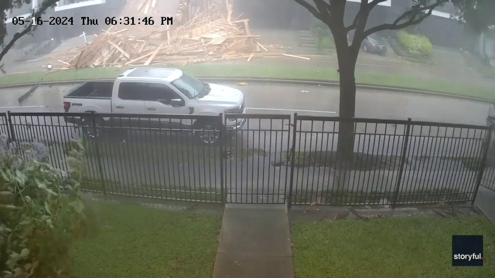 A townhouse under construction collapsed as a deadly storm hit Houston, Texas, on Thursday. Footage taken by Jeff Baker shows an electrical spark flashing over a residential Houston street before the wooden framing of a structure collapses into a pile of rubble.