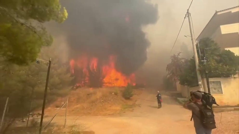 A video shared by a journalist in Greece shows intense flames and thick smoke from a massive wildfire burning outside Athens as hundreds of residents flee for safety.