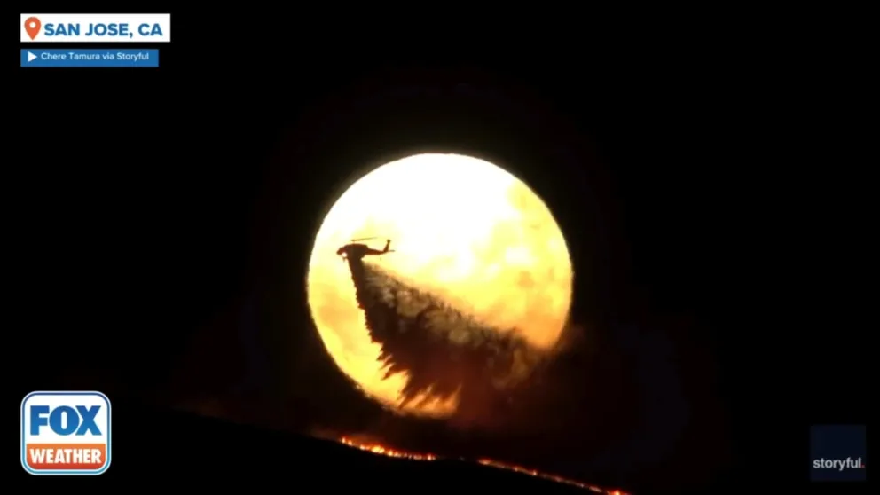 A shot of the first supermoon of 2024 rising over San Jose took on epic proportions on Monday, when it framed a helicopter dropping retardant on a raging wildfire.