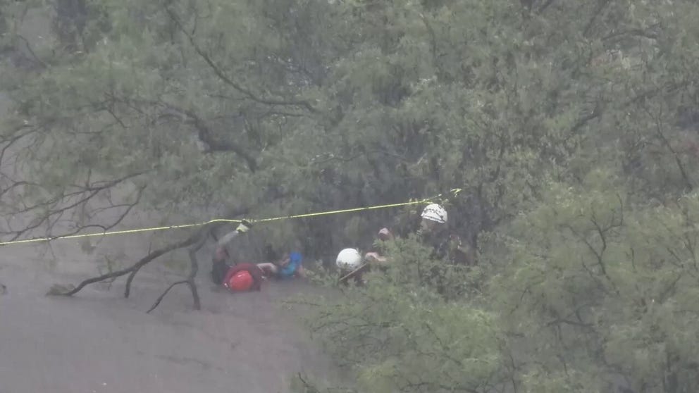 First responders rescued three men, one woman and a 3-year-old as they were hanging onto a tree to escape powerful floodwater in San Angelo, Texas.  (Courtesy: Texas Game Warden/ Texas Park and Wildlife Dept / TMX)