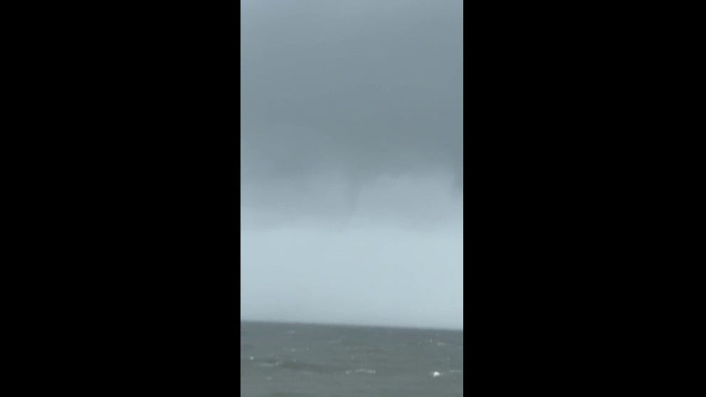 Footage caught by FOX Weather Correspondent Brandy Campbell shows an apparent waterspout forming over the water at Kure Beach, North Carolina, on Sunday. 