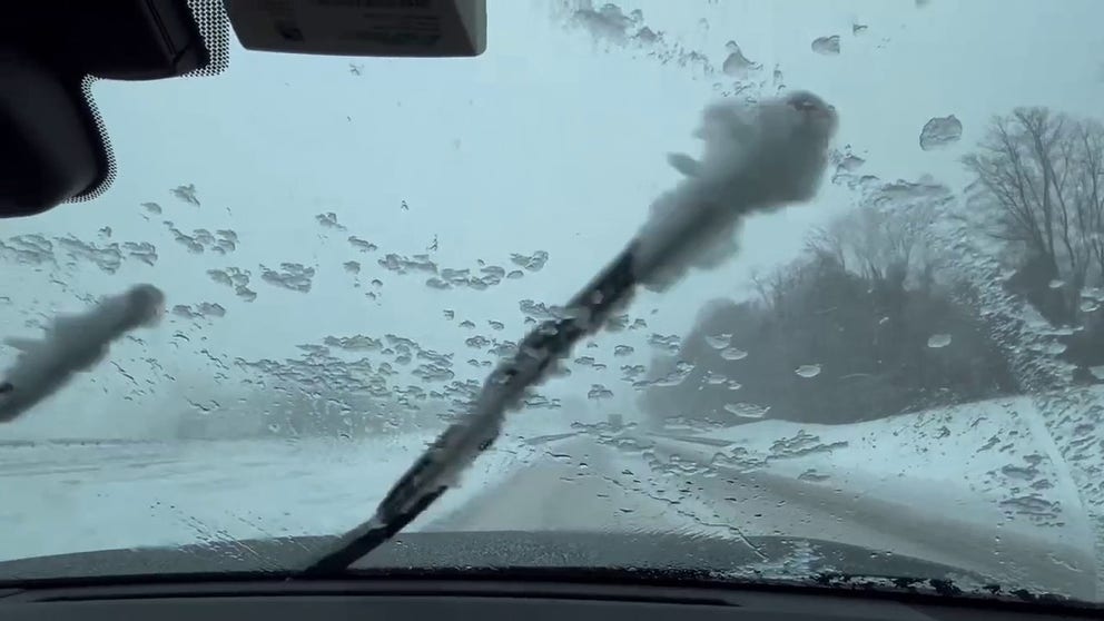 Video shows ice accumulating on the windshield amid heavy snow conditions on the road.