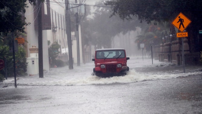 A motorist drives down flooded street in St. Augustine, Fla., as Hurricane Matthew moves up the Florida coast Friday, Oct. 7, 2016. Matthew was downgraded to a Category 3 hurricane overnight, and its storm center, or eye, hung just offshore Friday morning as it moved up the coastline, sparing communities the full force of its 120 mph winds. (AP Photo/John Bazemore)