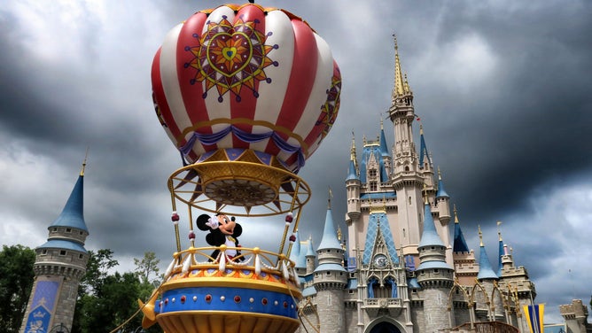 Mickey and Minnie appear under stormy skies during the afternoon parade, shortly before the Magic Kingdom at Walt Disney World in Lake Buena Vista, Fla., closed early due to weather spawned by Hurricane Dorian, Tuesday, Sept. 3, 2019.