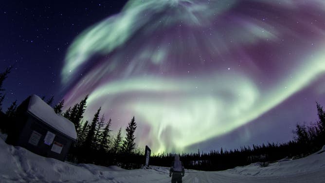 Blue, purple and green lights in the sky caused by an aurora over Canada.