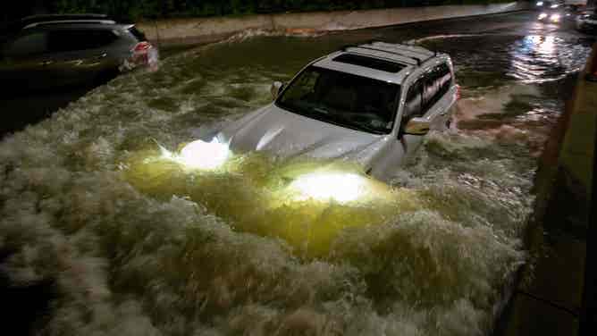 A white car in high flood waters in New York.