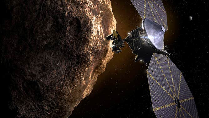 This illustration shows the Lucy spacecraft passing one of the Trojan Asteroids near Jupiter.