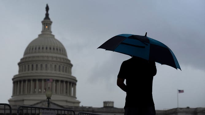 Man with umbrella in DC - Getty Images