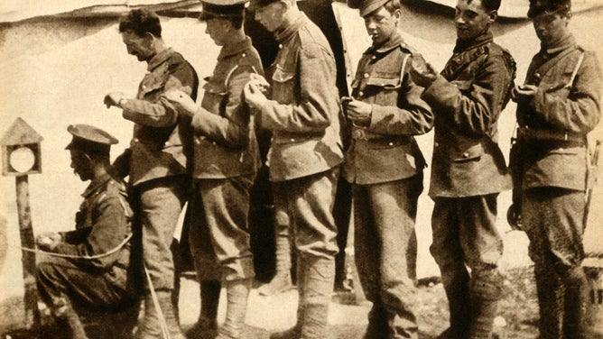 British soldiers synchronising their watches on the front line during World War I.