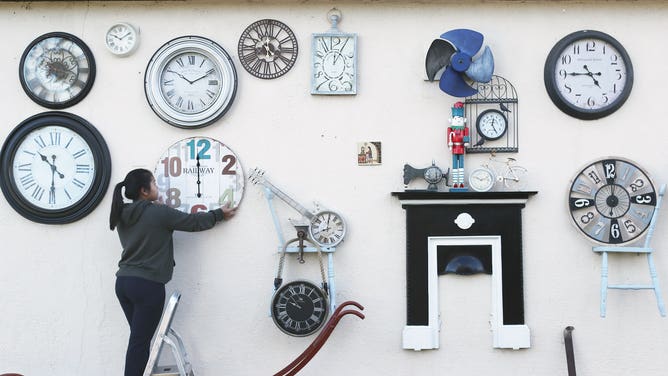 Sky Sangari Phunman changes the time on the clocks in her home. She collected clocks in memory of her grandfather, who specialized in horology, or the study of time.