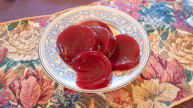 Slices of canned cranberry sauce at a Thanksgiving meal.