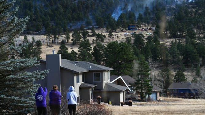 Residents watch as the Kruger Fire continues to burn on November 16, 2021 in Estes Park, Colorado. (Photo by RJ Sangosti/MediaNews Group/The Denver Post via Getty Images)