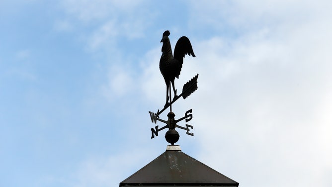 A rooster weathervane of an antique Cape style home in Duxbury, MA.