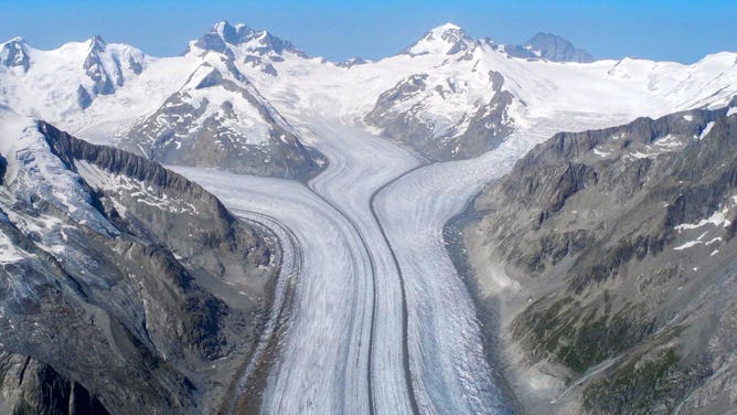 The Grosser Aletsch Glacier running between mountains in the Swiss Alps.