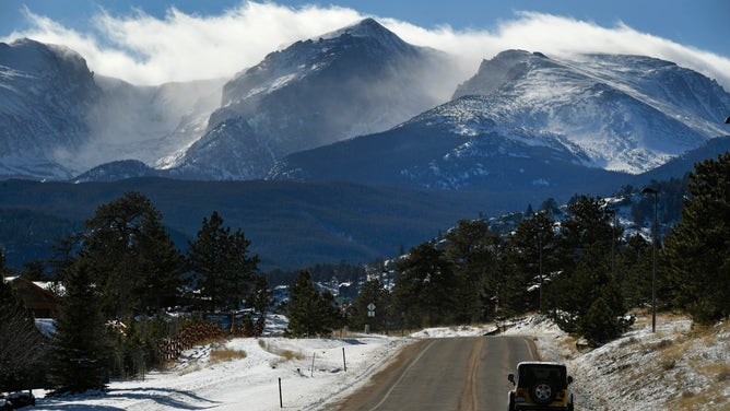 High winds blow snow off the craggy peaks of Rocky Mountain National Park.
