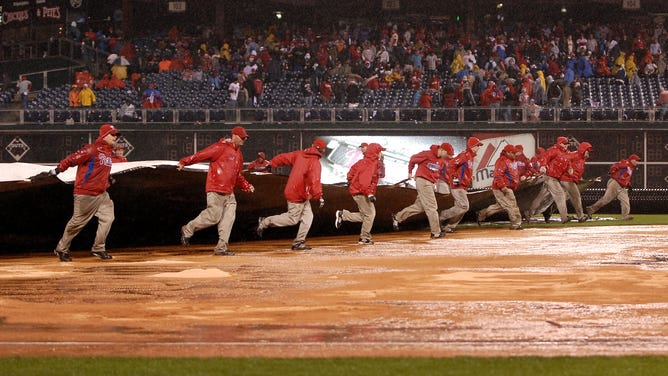 The grounds crew positions a tarp over the infield as rain falls during Game 5 of the 2008 World Series.