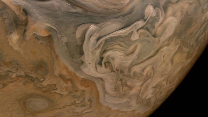 The three-dimensional character of Jupiter's cloud decks is captured in this image of the planet's North Equatorial Belt. Orange storms peek out from under banks of dark gray clouds. Lighter tan and gray clouds cast narrow shadows on the dark gray cloud bank below. At the top are the "pop-up clouds," parcels of air pushed up to the altitude at which ammonia ice condenses to make small, bright clouds. Image data: NASA/JPL-Caltech/SwRI/MSSSImage processing: Brian Swift