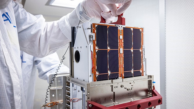 DART team engineers lift and inspect the LICIACube CubeSat after it arrived at Johns Hopkins APL in August. 