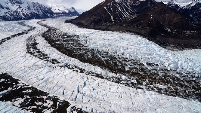 Accumulations of debris form lines known as "medial moraines" in Alaska's Klutlan Glacier. The glacier is about 40 miles long and flows from eastern Alaska into Canada’s Yukon Territory.