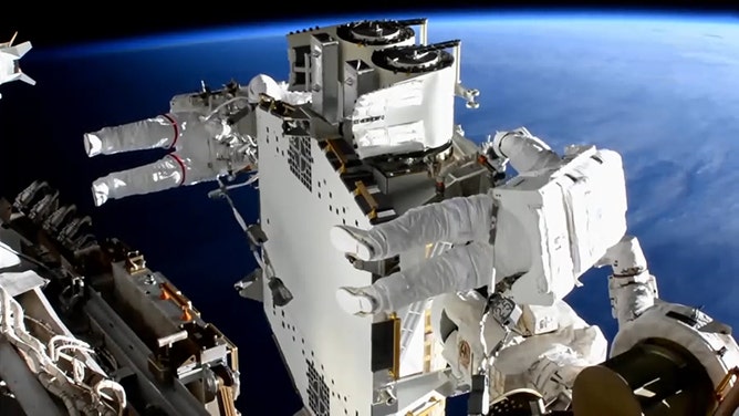 Spacewalkers Shane Kimbrough (foreground) and Thomas Pesquet work to prepare the second roll out solar array ready for installation an upcoming spacewalk.