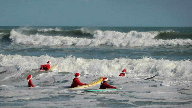Surfing Santas paddle out in Cocoa Beach on Christmas Eve. (Photo by Amanda Stratford)