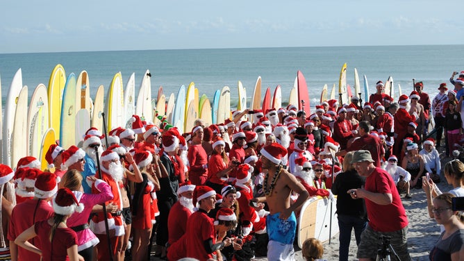 Centinaia di surfisti vestiti da Babbo Natale a Cocoa Beach alla vigilia di Natale.