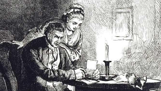 A man and woman read a letter by candlelight.