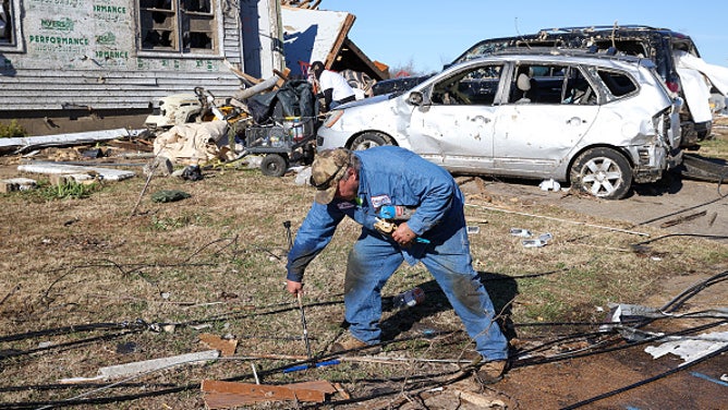 A man sifts through the wreckage after a tornado devastated his town of Mayfield, Kentucky on Dec. 10, 2021.