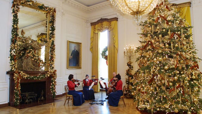 Musicians perform in the East Room of the White House, which was illuminated by Christmas lights.