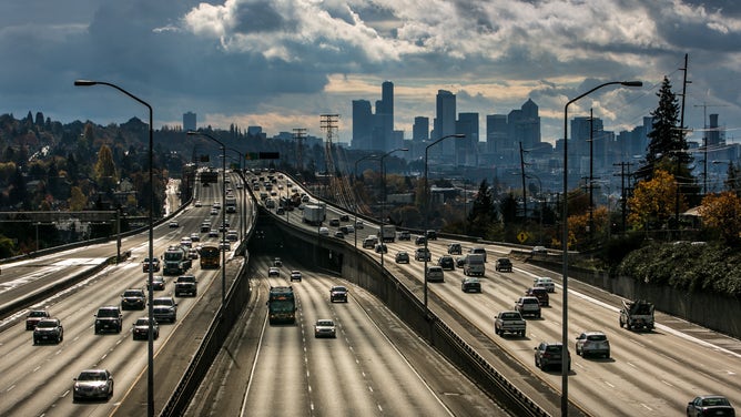 The downtown Seattle skyline is viewed from a bridge over Interstate 5.