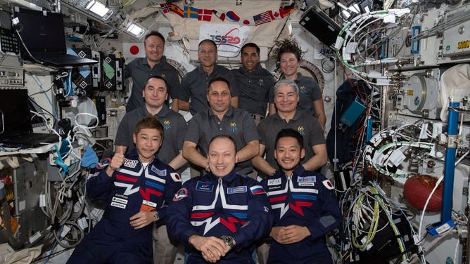 Japanese space tourists, Yusaku Maezawa (front left) and Yozo Hirano (front right) with cosmonauts and astronauts on the International Space Station.