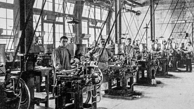 A 20th-century factory featuring workers and machines for casting types for typesetters.