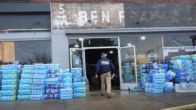 DAWSON SPRINGS, KENTUCKY - DECEMBER 16: A FEMA representative reaches out to residents at Redemption City as the recovery continues from last week's tornado on December 16, 2021 in Dawson Springs, Kentucky. Multiple tornadoes touched down in several Midwest states last Friday, causing widespread destruction and leaving scores of people dead and injured. (Photo by Scott Olson/Getty Images)