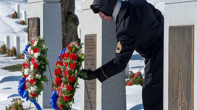 A member of the US Army Honor Guard adjusts the wreaths at the memorial site crew of the Space Shuttle Challenger during rememberance ceremonies for the crews of Apollo 1, and the Space Shuttles Challenger and Columbia January 28, 2016, at Arlington National Cemetery in Arlington, Virginia. The United States marked the 30th anniversary Thursday of the explosion of the Challenger space shuttle with a pledge to remember lost astronauts as it presses on toward Mars. / AFP / PAUL J. RICHARDS (Photo credit should read PAUL J. RICHARDS/AFP via Getty Images)