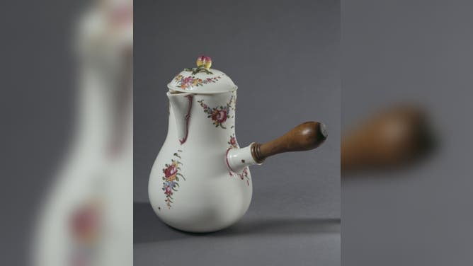 A ceramic chocolate pot with flower decorations, from Italy and dated 1780.