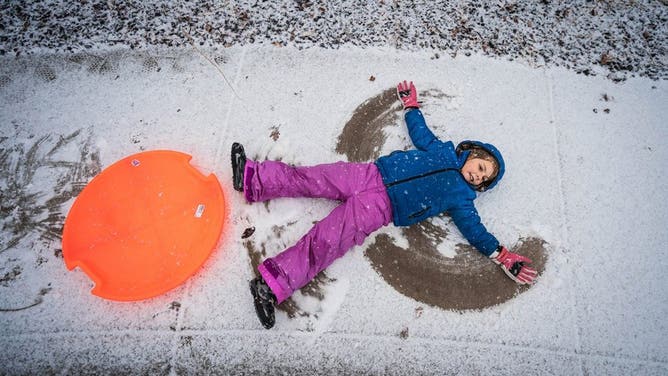 A child makes a snow angel.