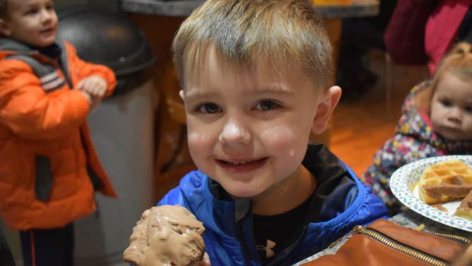 A little boy smiles as he eats ice cream for breakfast at Moonlight Creamery.