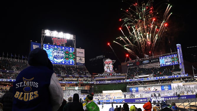 A fan gazes up as fireworks go off after the St. Louis Blues defeated the Minnesota Wild during the 2022 NHL Winter Classic at Minneapolis's Target Field.