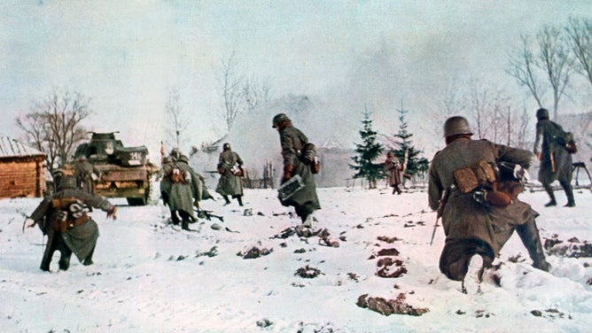German infantrymen following a tank towards Moscow in the snow, Russia, 1941. 