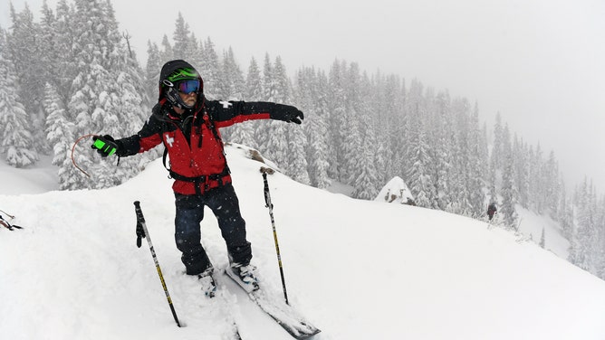 Ski patroller Eric Mercer Baumm throws explosives into deep powder in Crested Butte, Colorado.