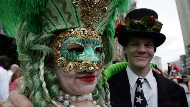 A couple waits for the Rex parade to start on Mardi Gras Day February 20, 2007 in New Orleans, Louisiana.