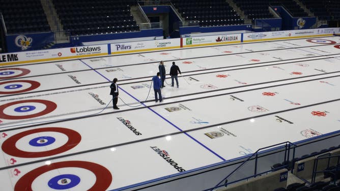 Ice makers prepare the ice for a curling competition in Toronto.