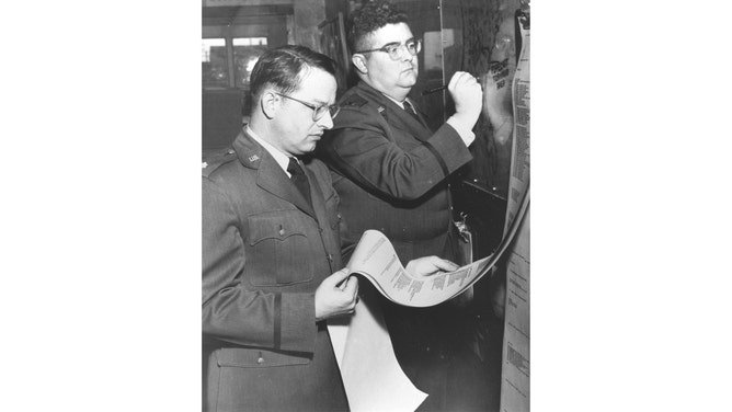 Maj. Ernest Fawbush (left) and Capt. Robert Miller (right) are photographed forecasting tornado activity at Tinker Air Force Base in Oklahoma.