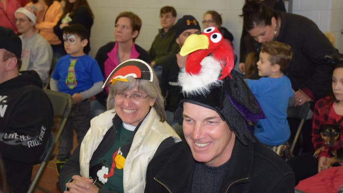 Pet contest attendees don buzzard day hats.