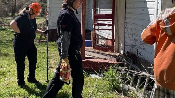 AIR team members work to get to a dog with puppes under a home in Gilmir, Texas after the March 21 tornado. (Image: Monica Ailey/Animal Investigation & Rescue)