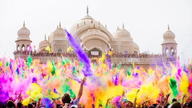 Colors are thrown in the foreground, with the temple in the background at the Festival of Colors in Utah.